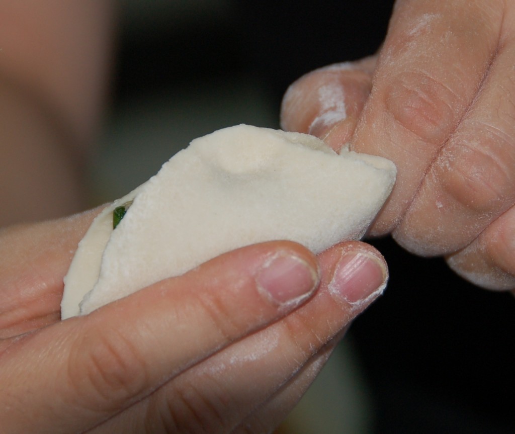 Pinching the dumpling skin closed.How to make Jiaozi
