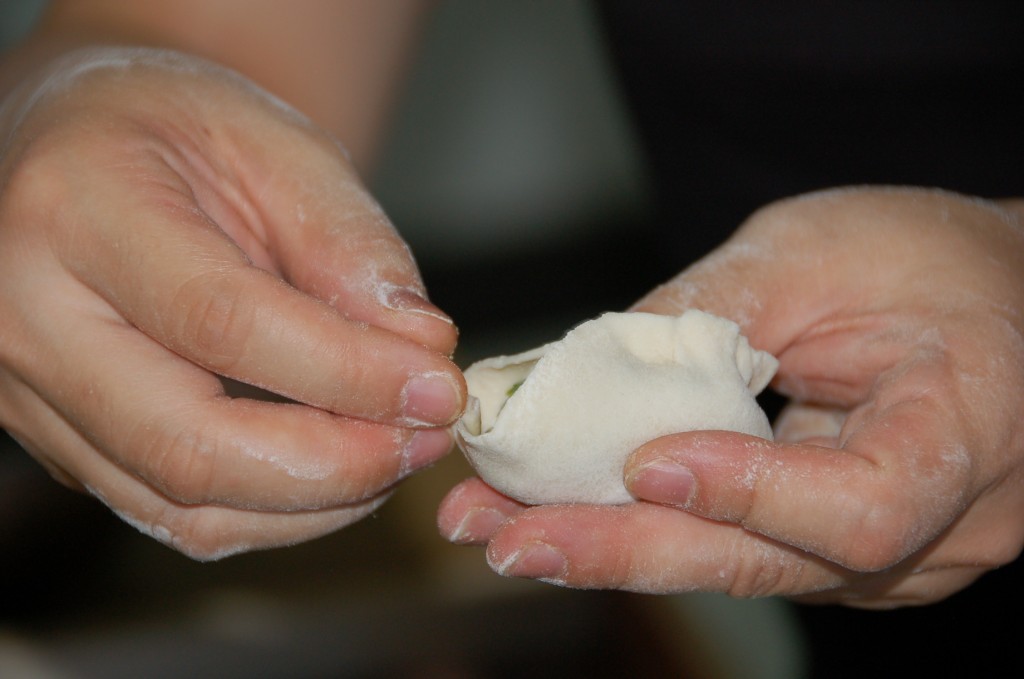 Pinching the dumpling skin closed.How to make Jiaozi