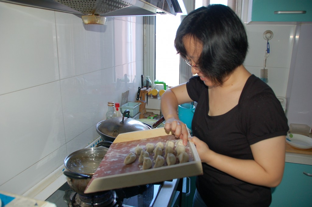 Laurette pushing the dumplings into boiling water.How to make Chinese Dumplings.Jiaozi