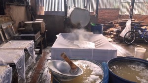 Pouring boiled tofu water into strainer. Balikpapan tofu factory, Indonesia
