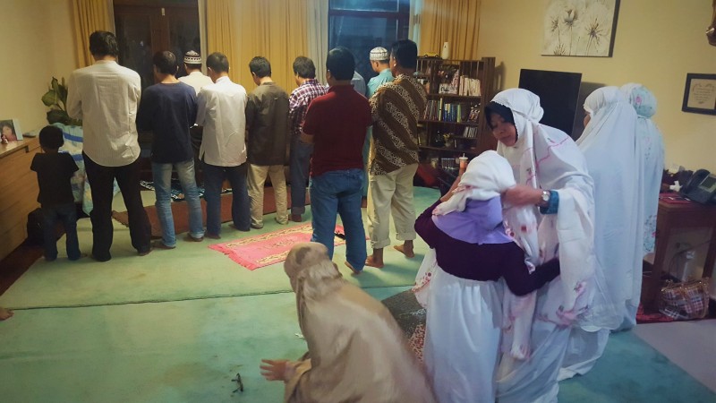 Donning hijab and full body cover (jilbab) prior to prayer. Iftar, Ramadan, Indonesia